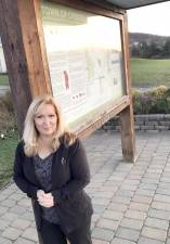 Tracy Schuh, president of the Preservation Collective, standing next to the informational sign located inside the existing kiosk on the Town of Chester’s Open Space at Knapp’s View. Provided photo.