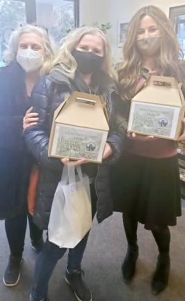 Chana Burston, right, hands a Passover Cooking Demo Tasting Box to Svetlana Askenazy, center, of Highland Mills and Anita Reich, left, of Harriman, prior to the virtual Passover Cooking demonstration.