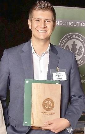 Architecture student Brandon Fuentes holding an award for his Palisade Hotel design project, the Connecticut Green Building Council’s 2021 Green Building Awards Student Design Award of Merit