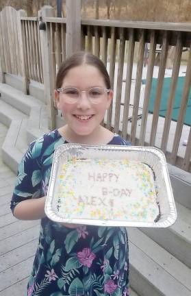 Rivkah Burston, 11, of Monroe makes a birthday cake for a community member who was self-quarantined.