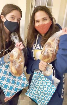 CTeen members Emily Stock and Haley Resti give each teen a “”Shabbat Package” to bring the spirit of Shabbat to their home at Chabad’s CTeen giving event “Tiles for Smiles.”