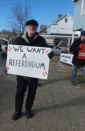This Legoland opponent at the sycamore vigil carries a poster with one of the Concerned Citizens for the Hudson Valley's top demands: let the people of the Town of Goshen decide about Legeoland (Photo by Frances Ruth Harris)