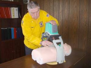 George Lyons, president of Goshen Volunteer Ambulance Corps, demonstrates Lucas, a priceless piece of new equipment for cardiac patients.