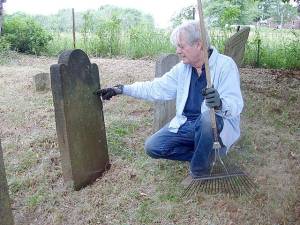 Village of Goshen Historian Edward Connor looks over one of the headstones at the Case Family Burial Grounds, hoping to read the name of the deceased individual. The cemetery has been on Sarah Wells Trail since 1761.