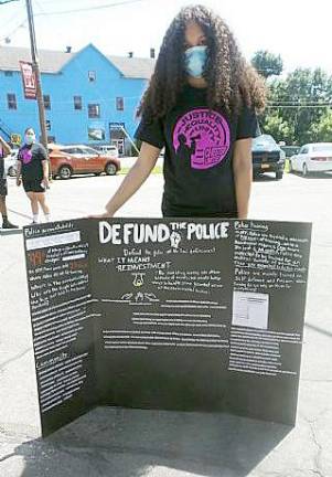 Erica Ramos with defund the police poster.