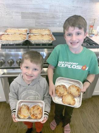 Young volunteers making mini lasagnas for a requester.