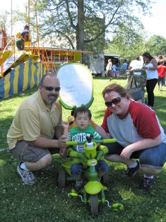 Great American Weekend brings on the crowds Logan Stamp, two and a half, in his fancy stroller/tricycle, with dad Bill and mom Erin.