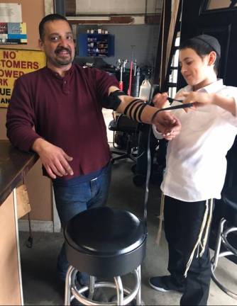 Mendy Borenstein (right) helping with prayers at TK auto shop.