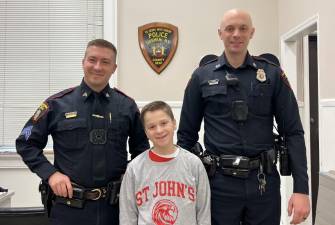 After donating some treats to the police department, St. John’s fifth-grader James “JJ” Ferreira had his photo taken with the officers.