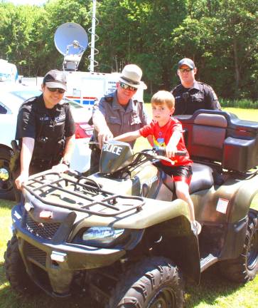 Christopher Unold of Chester sits atop an ATV with (from left) police Officer Ashley Feldt, park Ranger Ray Bombino Jr., and Sgt. Timothy Meade (Photo by Ed Bailey)