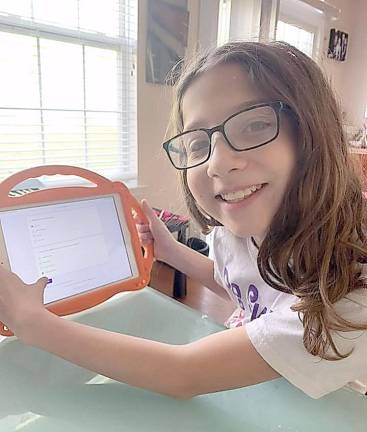 Lizzie Deskin of Monroe fills out a quiz following a virtual Hebrew School class.