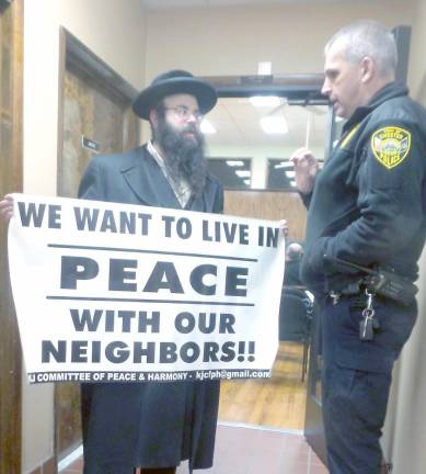 Town police Sergeant David Slowik told Rabbi Yoel Loeb that the previous administration passed a ruling that banners were not allowed in town meetings. Loeb was not asked to leave, and the banners were not removed.