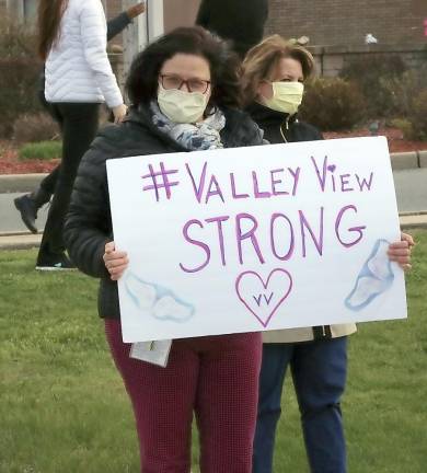 Anna Brass, a staffing manager at the Valley View Center for Nursing Care and Rehabilitation, holds up a sign during Thursday’s parade.