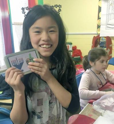 Sophia holding her new travel menorah.