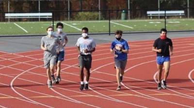 Greg Hannibal, third from left, practicing with his Goshen High School cross country teammates at the school's track.