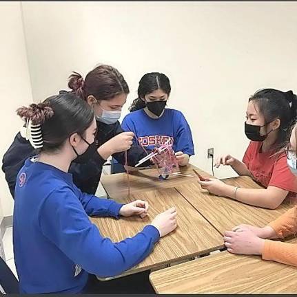 Several members of the Goshen High School Odyssey of the Mind team collaborate to solve a problem.