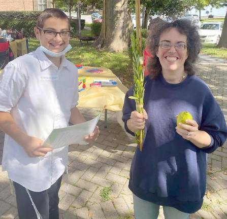 Zushi Borenstein and Delilah Silverblatt do the lulav shake, the lulva being the closed fond of the date palm tree. It is one of the four species used during the Jewish holiday of Sukkot. The other species are the hadass, aravah and etrog. When bound together, they are commonly referred to as “the lulav.”