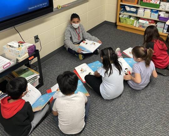 Fifth grader Luis Mora reading We're All Wonders to first graders. Photos provided by the Chester Elementary School.