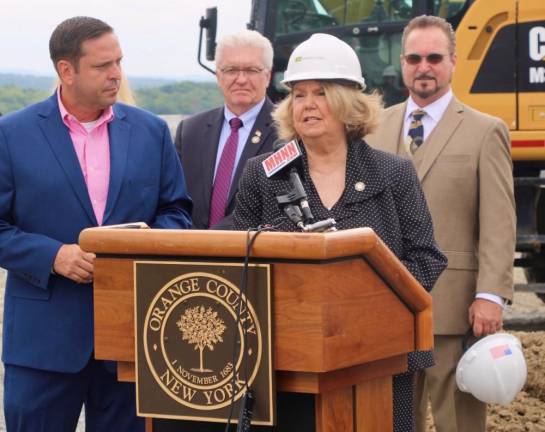 Chairwomen of the Legislature Katie Bonelli speaks at the groundbreaking as Orange County Executive Steven M. Neuhaus looks on. In the background are (from left to right) Legislators Barry Cheney and Joe Minuta.