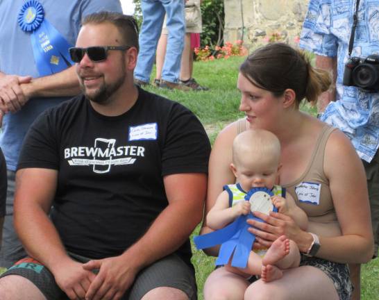 A great day for the Bull family Youngest boy, Evan Johnson, 8 months, with parents Curtis and Heather, decided to taste his ribbon. (Photo by Ginny Privitar)