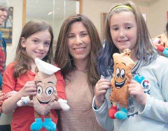 Heather Sentell, 8, of Monroe, and Juliana Loftus, 9, of Goshen, show their “Challah Pillows” to Chana Burston.