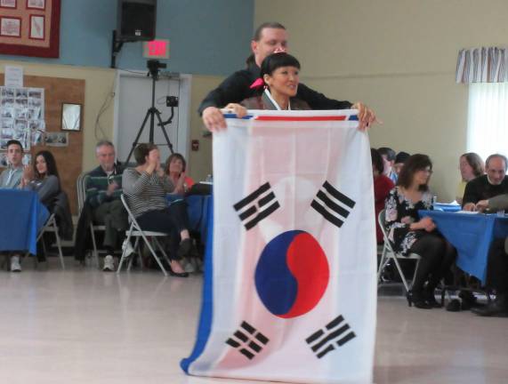 A wish, expressed through dance, uniting two Koreas Yuri Nam-Wasserman and partner Vasily Nikeshin hold flags of North and South Korea together. (Photo by Ginny Privitar)