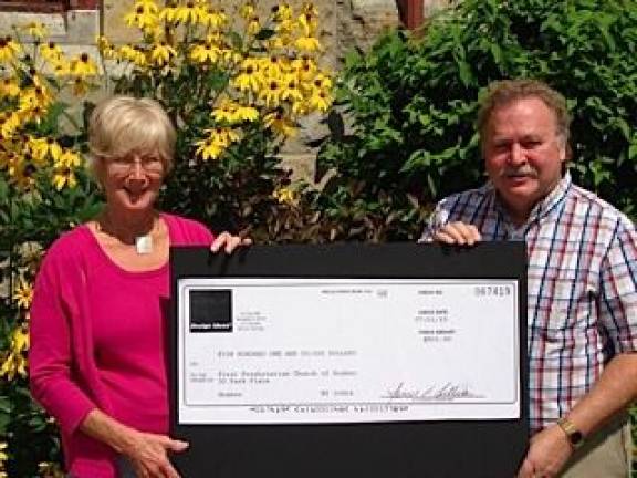 Linda Mabie wins $500 to help preserve church's Tiffany windows Linda Mabie, owner of Linda's Office Supplies in Goshen, presents a check for $500 to Rev. David Kingsley, pastor of the First Presbyterian Church of Goshen, to aid in the preservation of the Tiffany windows. Mabie's entry in the GelGems online contest won second place. (Photo by Geri Corey)