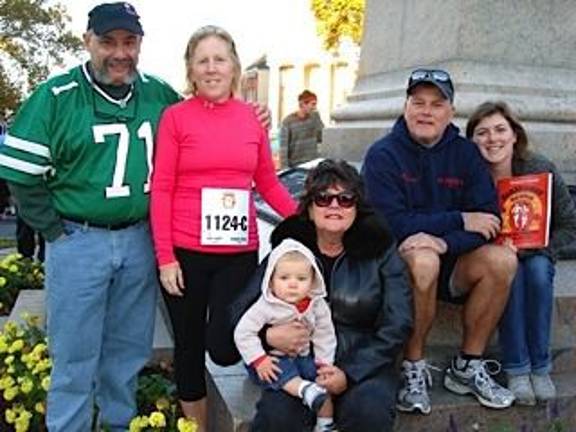 Runners rack up miles at first-ever marathon It’s a family affair grouped around Brady McElroy, sitting on his Aunt Mary Ellen Benedetti’s lap. Others include (from left(): Uncle Charlie Benedetti, grandmother and racer Peggy Halayko; grandpa and racer Steven Halayko, and Michele McElroy, Brady’s mom. (Photo by Geri Corey)