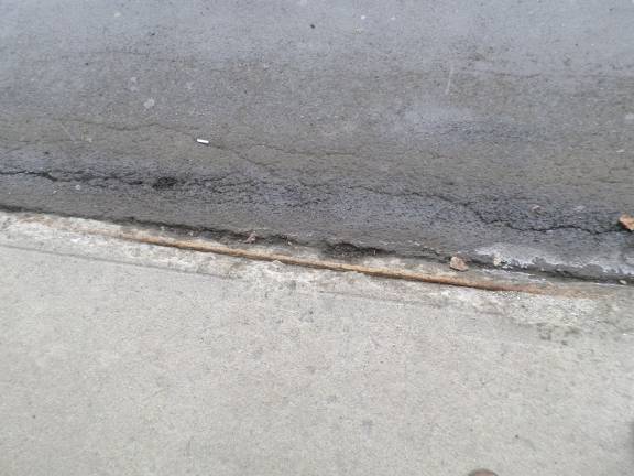 A rod sticks out of the sidewalk at the Goshen Center Plaza in front of the Verizon store (Photo by Nathan Mayberg)