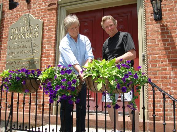 Merchants: Goshen is on the rebound Maureen and Ray Quattrini decorate Main Street with flowers, a project of the Goshen Garden Club. The Quattrinis have lived in Goshen for 40 years, and their involvement is a way of saying, “Thank you for accepting us into the community.” (Photo by Geri Corey)