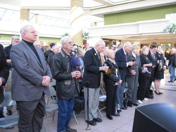 70 years ago, in a dark and snowy wood Members of the service doffed their caps during prayer (Photo by Ginny Privitar)