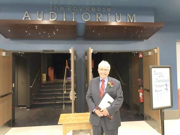 Roy Reese, the man of the hour, pauses under the new signage for The Roy Reese Auditorium.