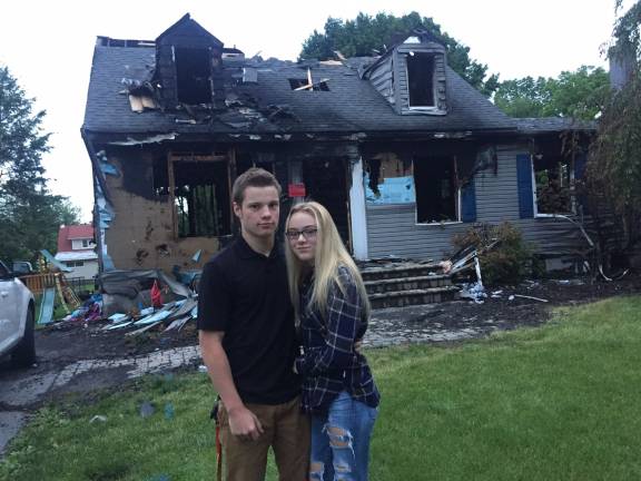Two young heroes save family from devastating fire Anthony Battiato and Kasandra Catlett in front of the devastated house on Elm Street (Photo by Phyllis Battiato)