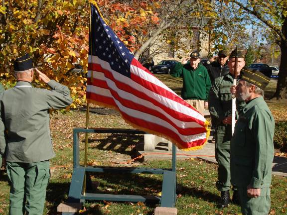 A stirring ceremony at Goshen memorial Veterans salute the flag. On the right is VFW Commander Ray Quattrini (Photo by Geri Corey)