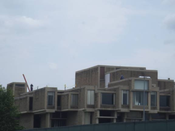 Construction workers tend to the roof of the the Orange County Government Center in Goshen, where an estimated $7 million demolition of the structure is being completed. (Photo by Nathan Mayberg)