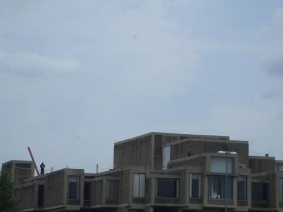 Construction workers tend to the roof of the the Orange County Government Center in Goshen, where an estimated $7 million demolition of the structure is being completed. (Photo by Nathan Mayberg)