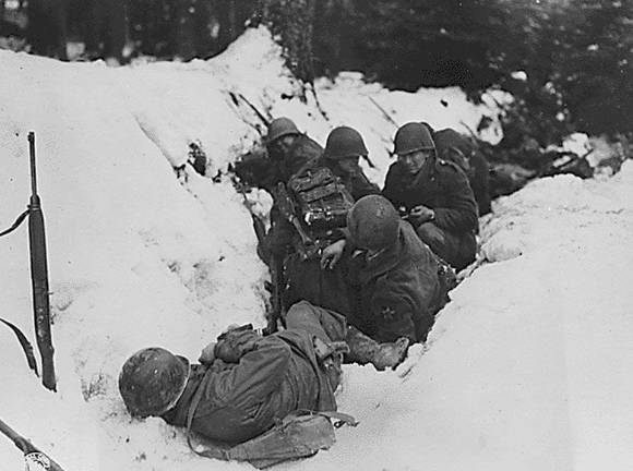 70 years ago, in a dark and snowy wood Members of the 2nd Infantry Division struggle to survive in the snow during the Battle of the Bulge.