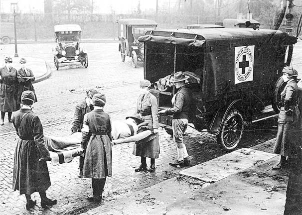 Then and now Influenza epidemic in United States. St. Louis, Missouri, Red Cross Motor Corps on duty, October 1918. (National Archives)