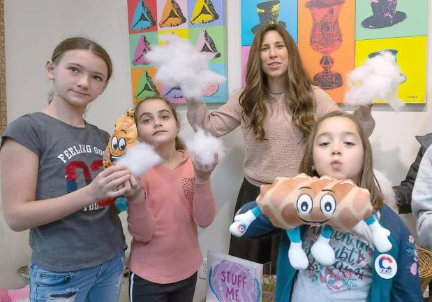 Kaylee Fried, 10, of Monroe, Yasmine Kalkstein, 10, of Monroe and Libby Einav, 7, of Harriman stuff their “Challah Friends” together with Chabad Hebrew School director Chana Burston - as they get ready to bake Challah at Chabad of Orange County’s Loaves of Love event.