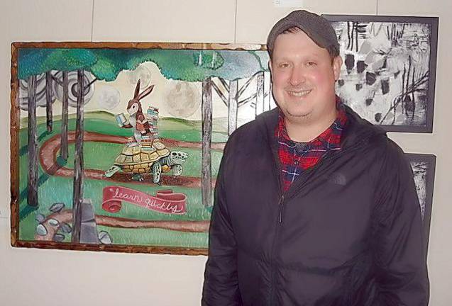 Goshen artists following where the road leads Goshen Art League President, Robb Gomulka stands with his amusing three-dimensional work, “Learn Quickly.”