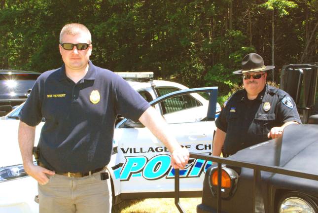Village of Chester Police Chief Peter Graziano and Sgt. Joseph Verbert by the village&#x2019;s patrol car and Humvee, both on display (Photo by Ed Bailey)
