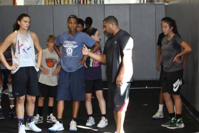 Coach Rudy Charles Jr. wants youngsters to learn from his mistakes Rudy Charles Jr., center, speaks with young athletes during one of his coaching sessions (Photo by Dandre Liburd)