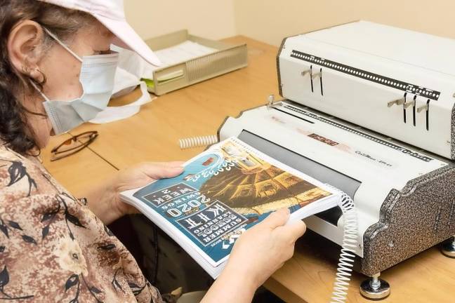 An Orange-Ulster BOCES staff member uses a machine to bind a workbook at the Regional Education Center at Arden Hill in Goshen. Photos by Tom Bushey.