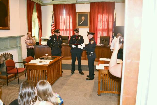 Sgt Yates is presented a plaque by PBA President Detective Rob Kozlowski, as Trustee Tony Scotto and Chief Watt look on.