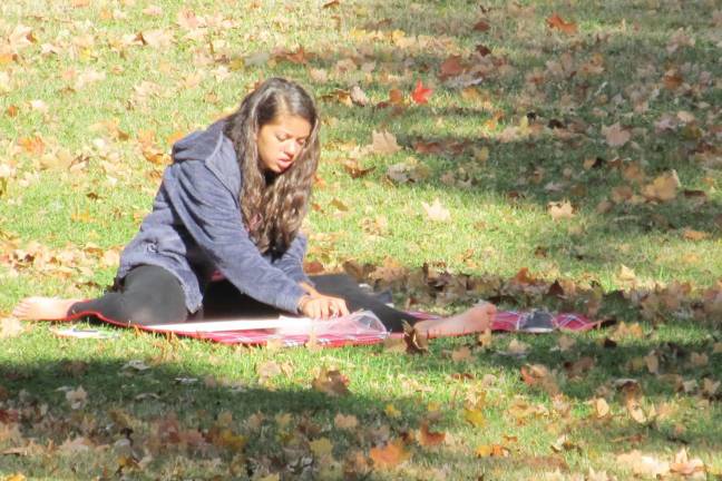 Creativity under an open sky Lauren Johnson paints among the autumn leaves.