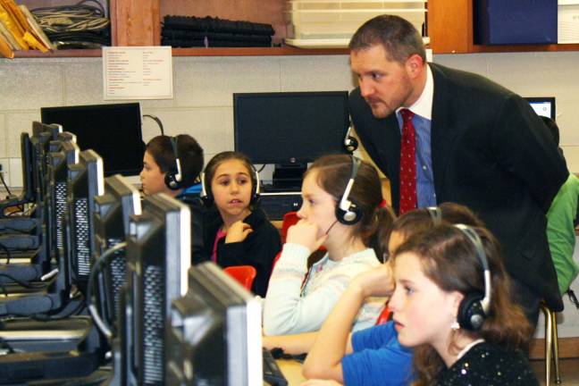 Goshen Intermediate School Principal Jason Carter looks over students' efforts.