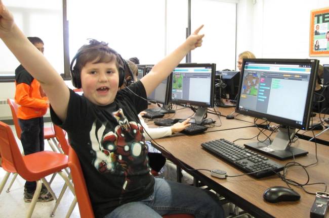 Coding is 'like playing,' young programers say An exuberant Logan DeCastro really enjoys coding games. (Photo by Ginny Privitar)