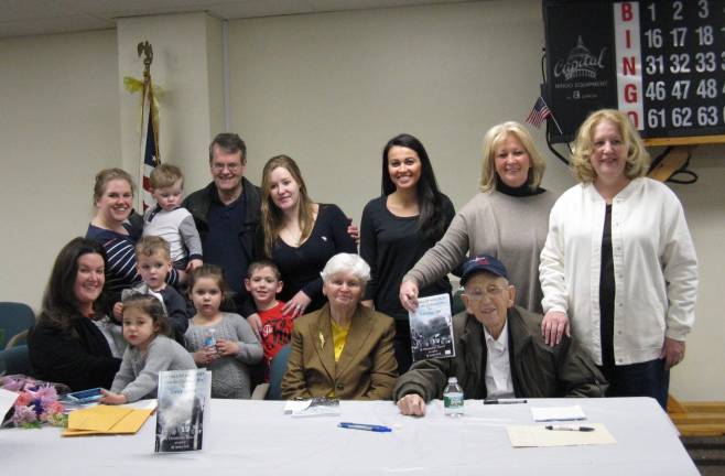 Author Dominic Kelly shares his life of adventure Photos by Ginny Privitar Local author Dominic Kelly (seated at far right), with wife Mary next to him, surrounded by their family.