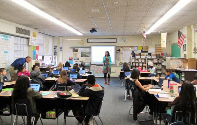 Coding is 'like playing,' young programers say Mr. Jeff Knight’s fourth-grade class listens to the computer lab aide, Mrs. Monali Verma (Photo by Ginny Privitar)
