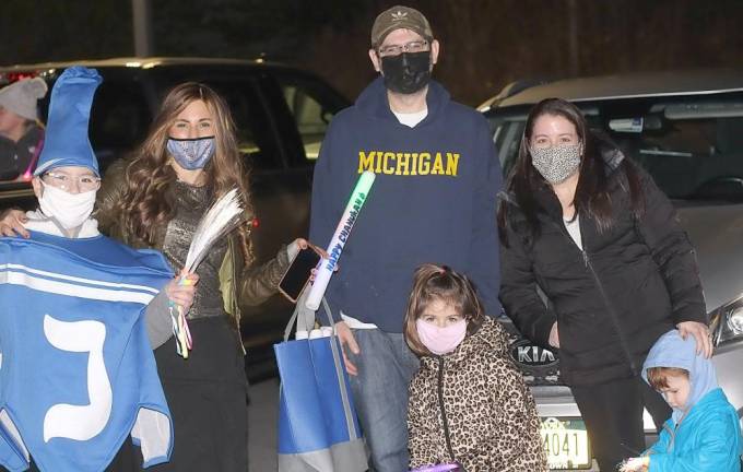 The Orman family of Goshen poses for a photo with Dreidel Mascot Rivkah Burston and Chana Burston at Chabad’s Hanukkah Drive-in Experience.